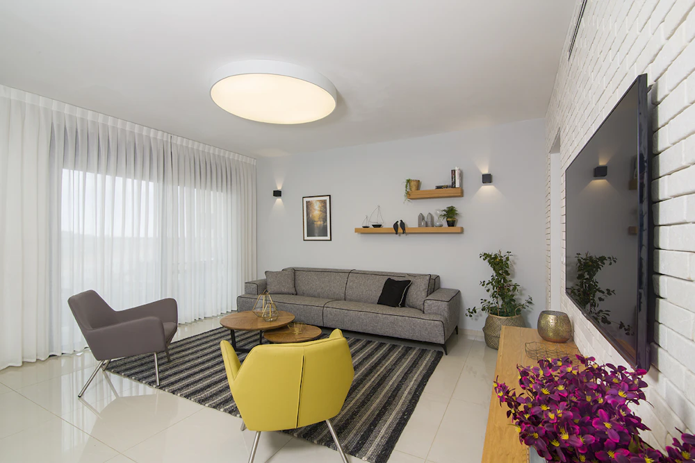 סלון עם קיר בריקים וכורסת חרדל.