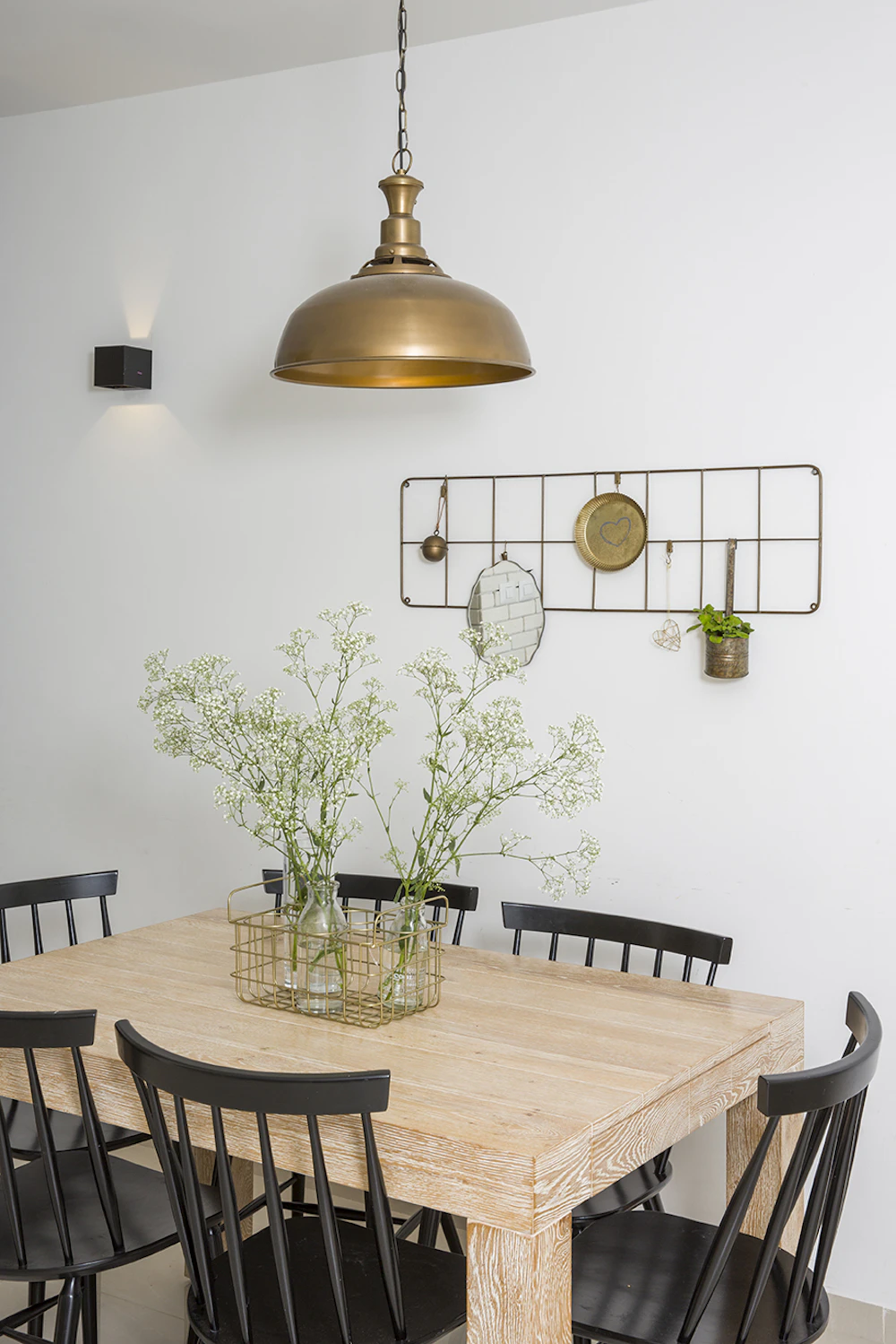 גוף תאורה מוזהב בפינת האוכל.