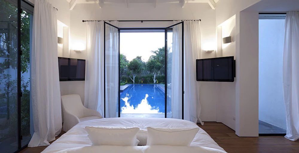 חדר שינה לבן משקיף לבריכה