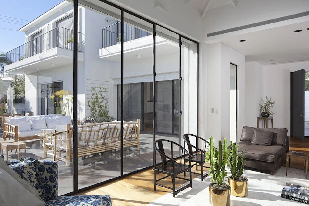 סלון עם מבט לברכה. גווני שחור-לבו, אפור ועץ