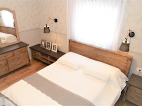 חדר שינה הורים עם מיטה זוגית וקומודה