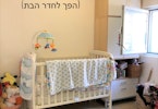 מיטת תינוק עם ארון אחסון ליד בחדר מואר